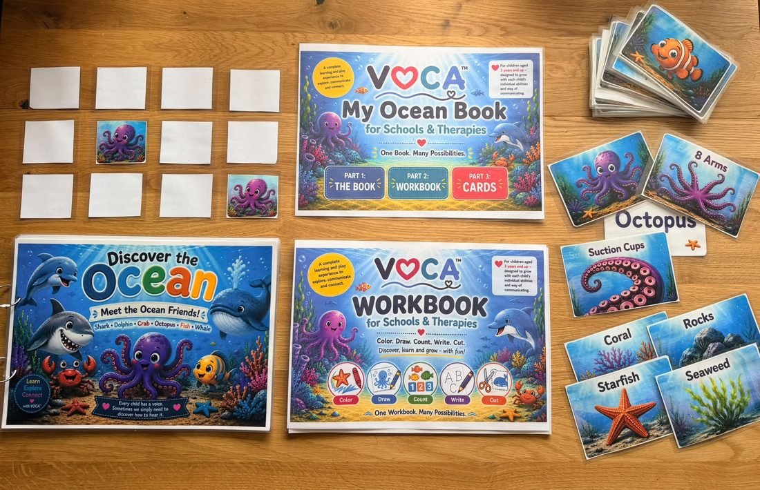 Das VOCA-Set auf einem Holztisch: das Bilderbuch Entdecke den Ozean, das Arbeitsheft, Bildkarten und ein Memory-Spiel.